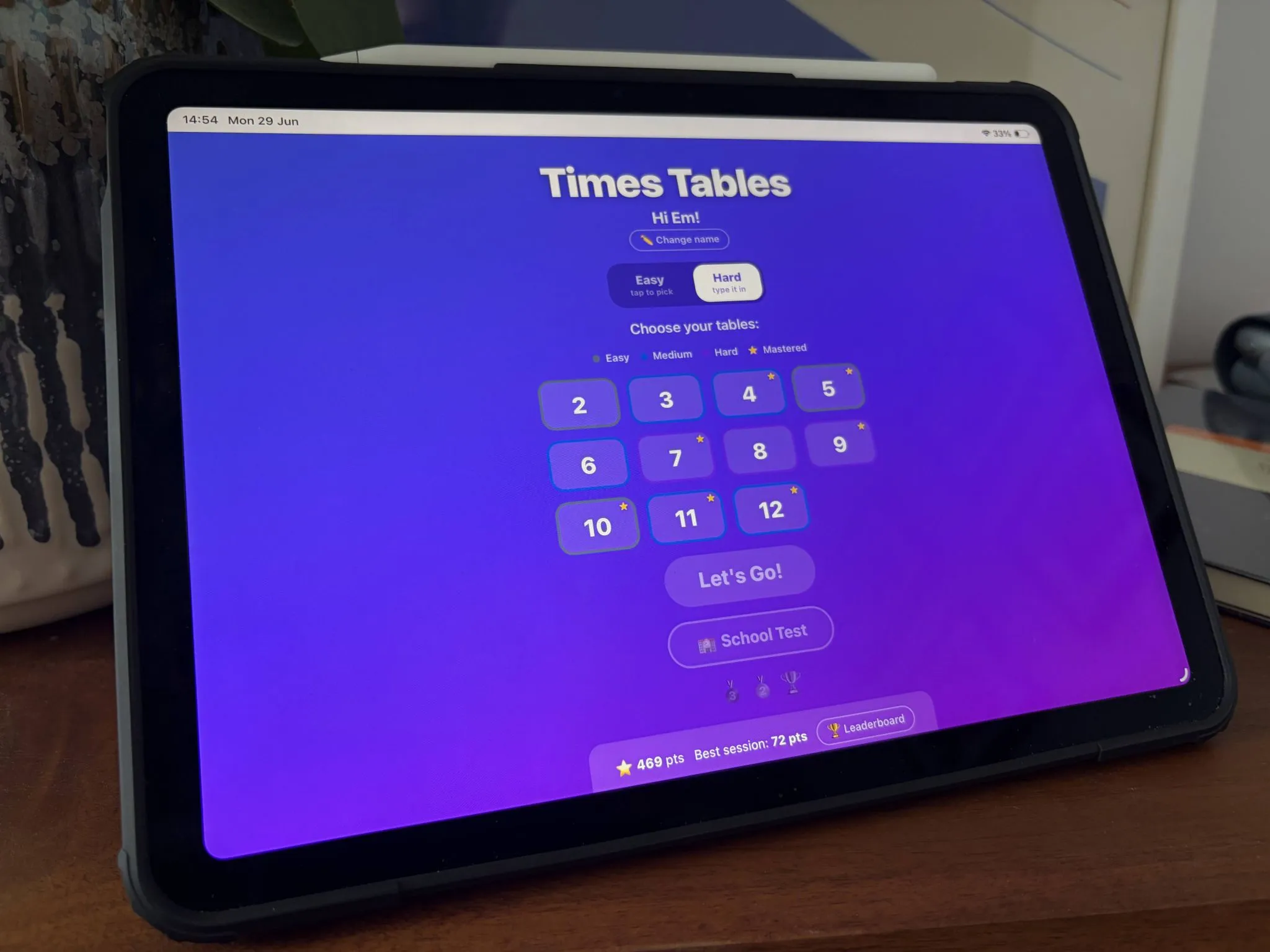 An iPad showing the Times Tables app home screen, with easy and hard modes and a grid of tables from two to twelve to choose from.
